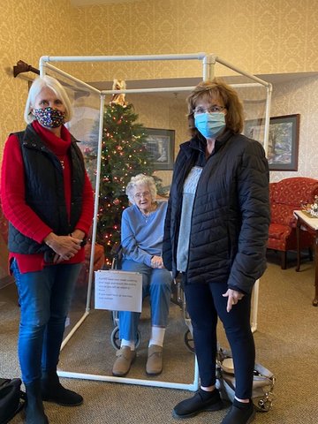 Dorothy Ream, a resident at Sylvia G. Thompson Residence Center, enjoyed an in-person visit with her niece, Debbie Wilson, left, and her daughter, Linda Gibbs, right, behind the safety of a Plexiglass visitation station. Current in-person policies are limited to end-of-life care only.
