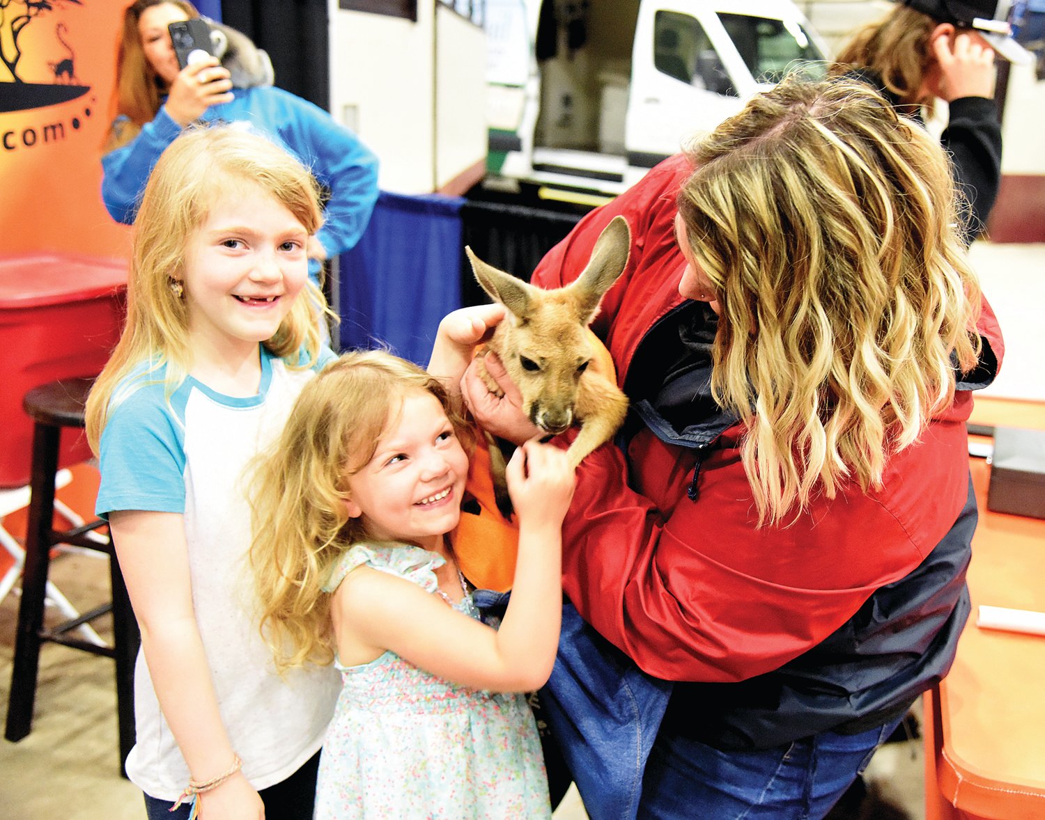 Rowyn Reed, 8, left, and Reagan Reed, 4, are all smiles as their mother, Rechelle Reed, holds a kangaroo while their father Ryan Reed takes photos Saturday at the Home and Garden Show hosted by the Democrat inside the Mathewson Exhibition Center. For $5, vendor Thorni Ridge Exotics offered visitors the opportunity to have a selfie with a kangaroo, lemur and alligator.