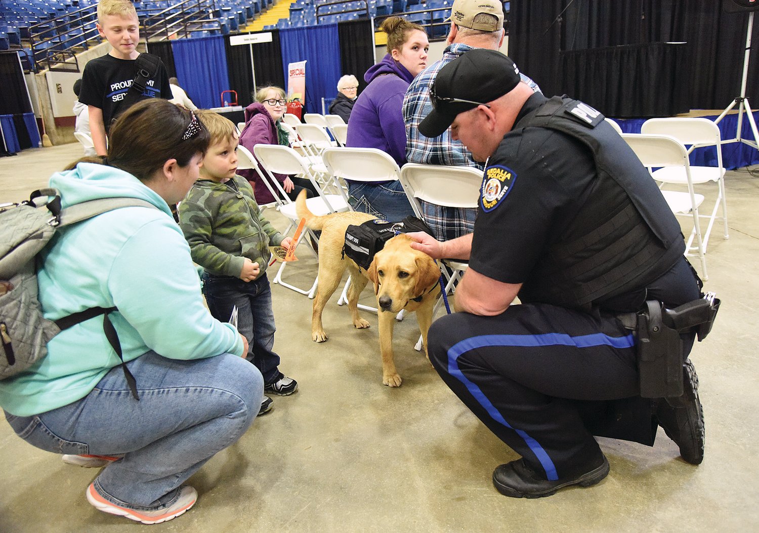 Sedalia Police Officer Antonio Karr and SPD therapy dog Kyah visits with Jackson Harbison, 3, and his mother, Victoria Harbison, of Sedalia, at the Home and Garden Show on the Missouri State Fairgrounds. SPD Sgt. Casey DeVorss said Kyah is new to the department and belongs to everyone. He added Kyah will bridge the gap between SPD and the community and “humanize the badge.”