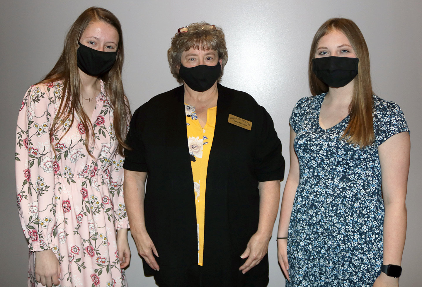 Smith-Cotton High School seniors Kylie Neal, left, and Emily Cote, right, are congratulated by Sedalia School District 200 Board of Education President Diana Nichols for their selections as Tiger Legacy scholarship recipients at the April 19 board meeting in the Heckart Performing Arts Center.