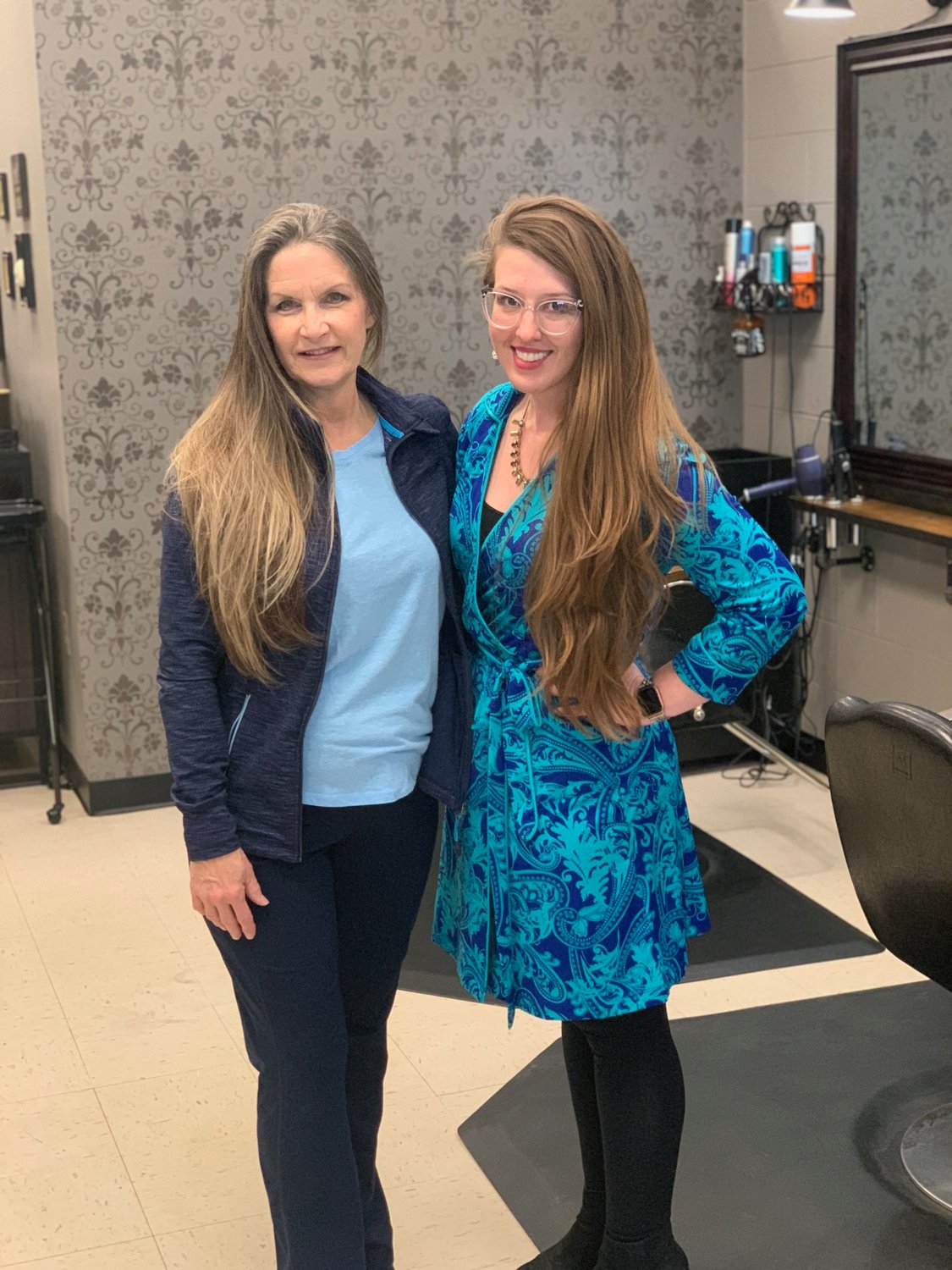 Annette Smith, left, and Dr. Misty Todd show off their long locks before having their hair cut at The Parlour hair salon in Sedalia. Smith and Todd work at Bothwell Regional Health Center and teamed up to donate their cut hair to Wigs for Kids, a nonprofit organization that provides wigs to children free of charge.